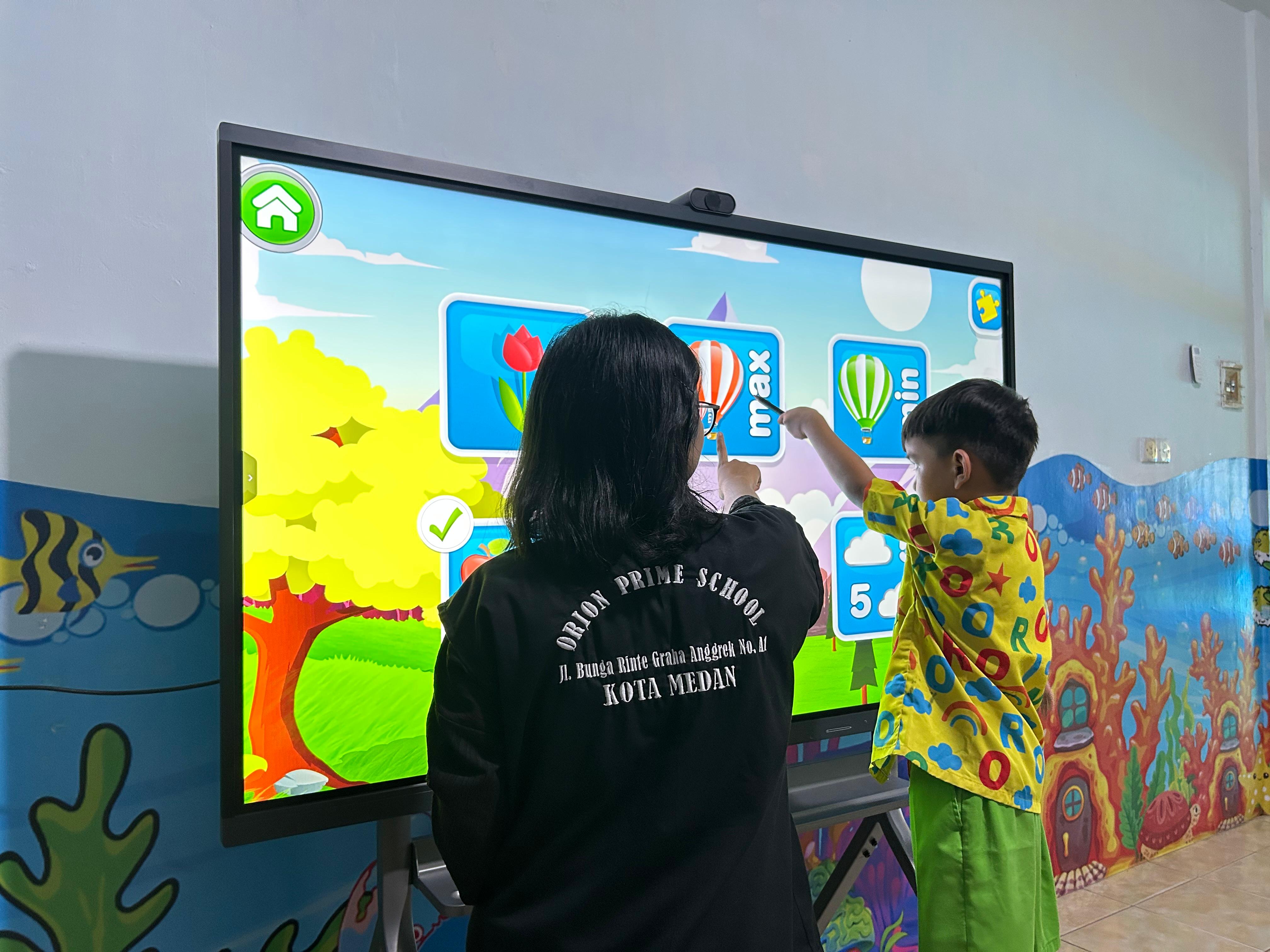 Guru dan murid belajar lewat papan layar sentuh interaktif